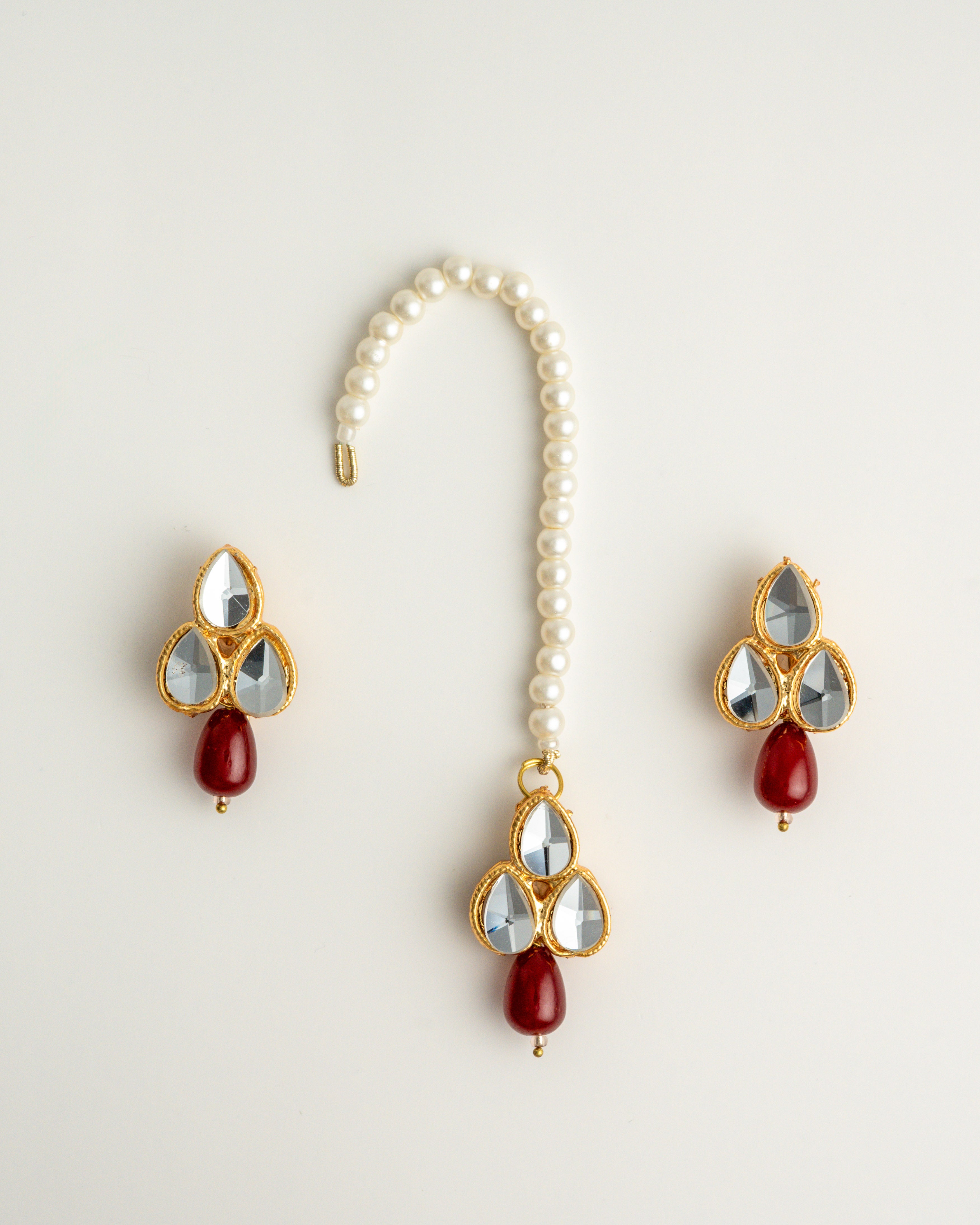 maroon earring set with white beads and gold accents on a white background