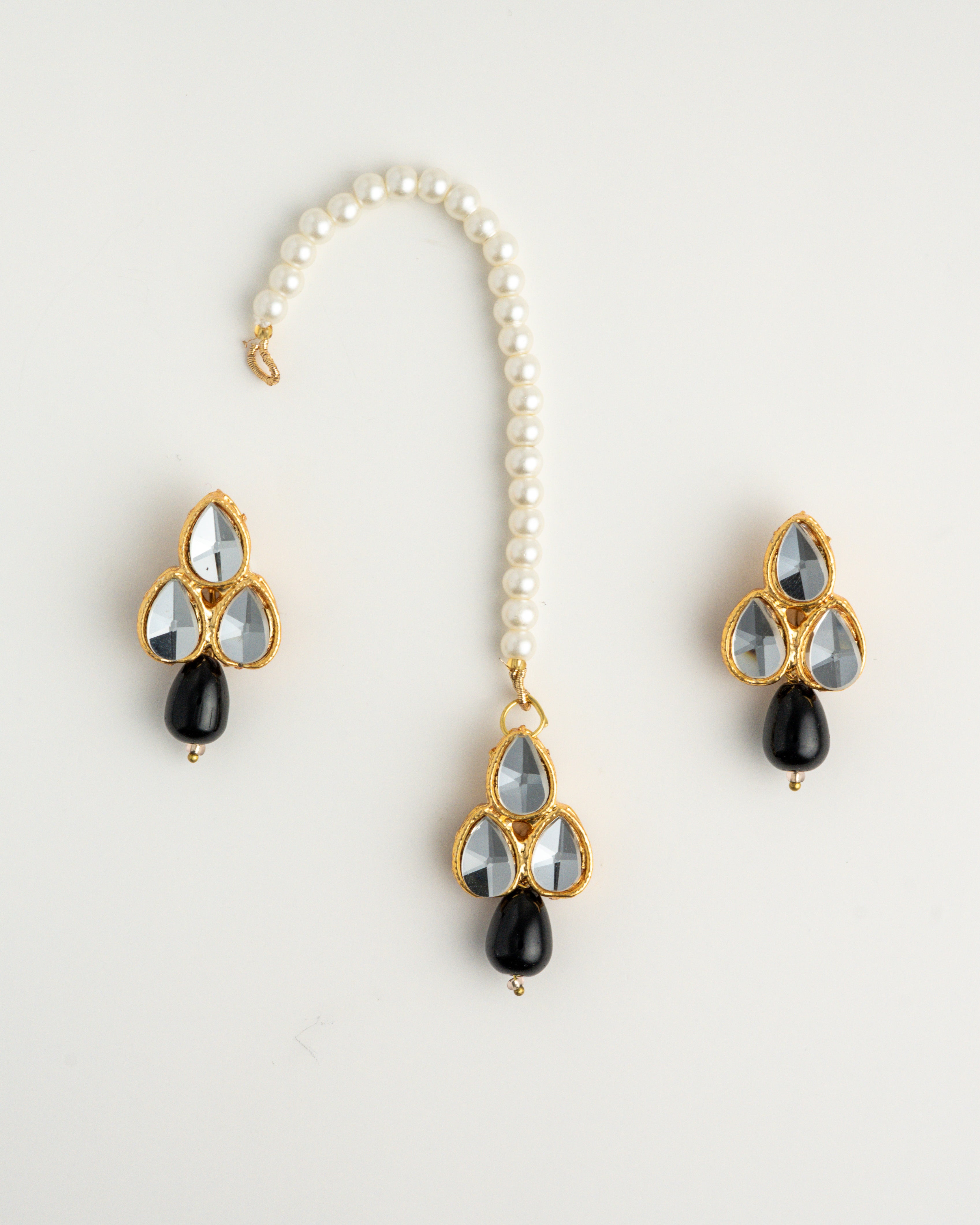 black earring set with white beads and gold accents on a white background