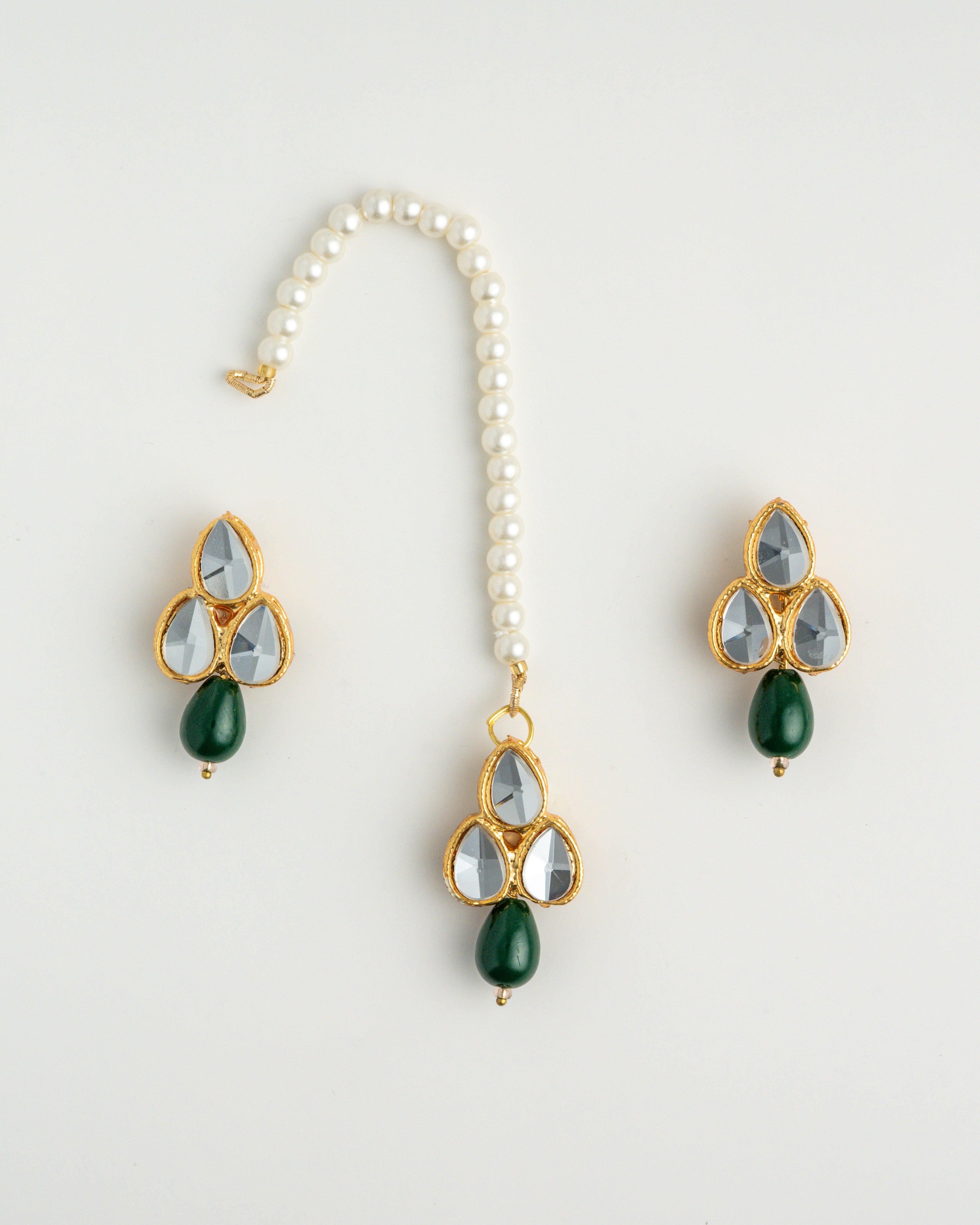 green earring set with white beads and gold accents on a white background