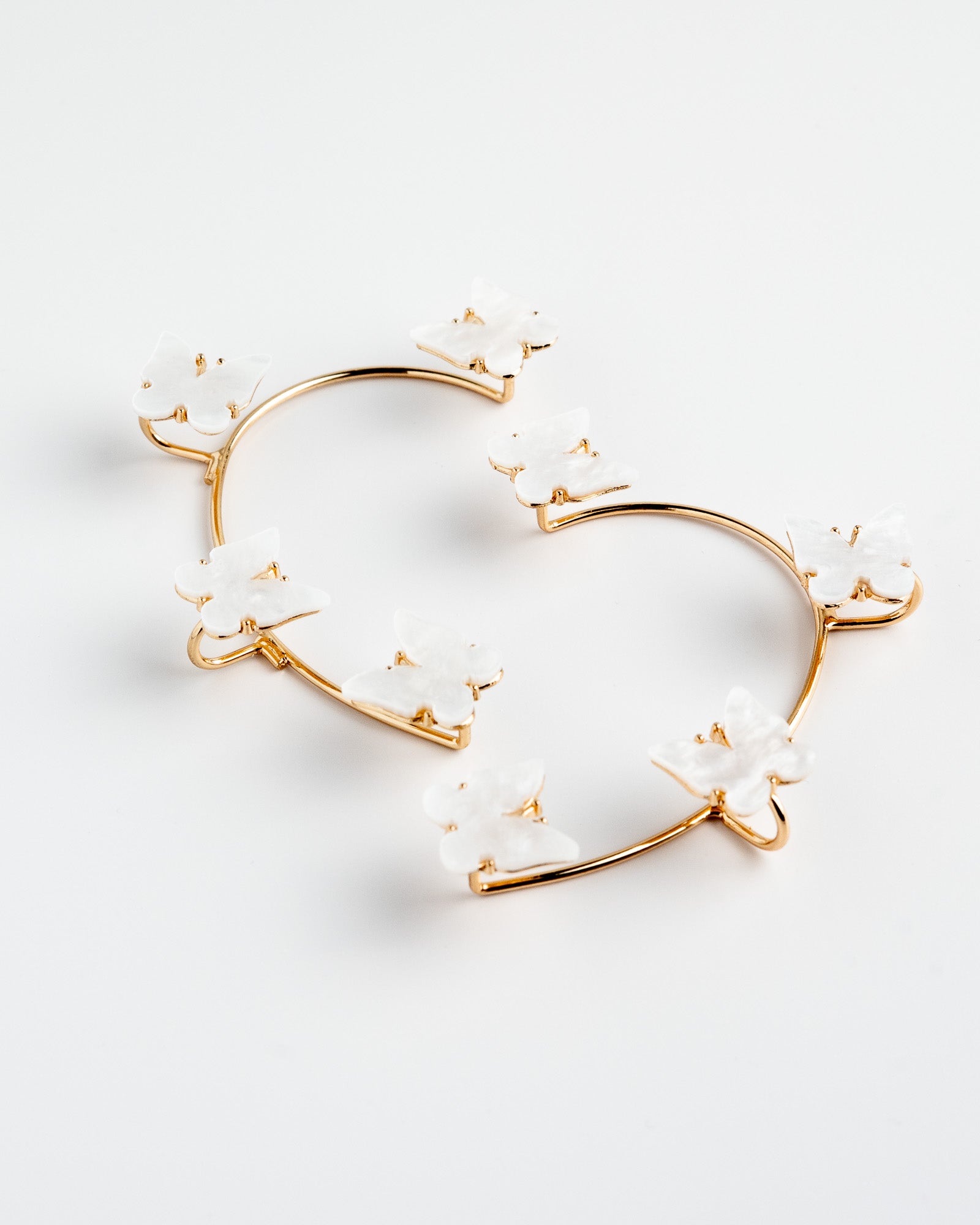 Heart-shaped earrings with white floral elements on a white background