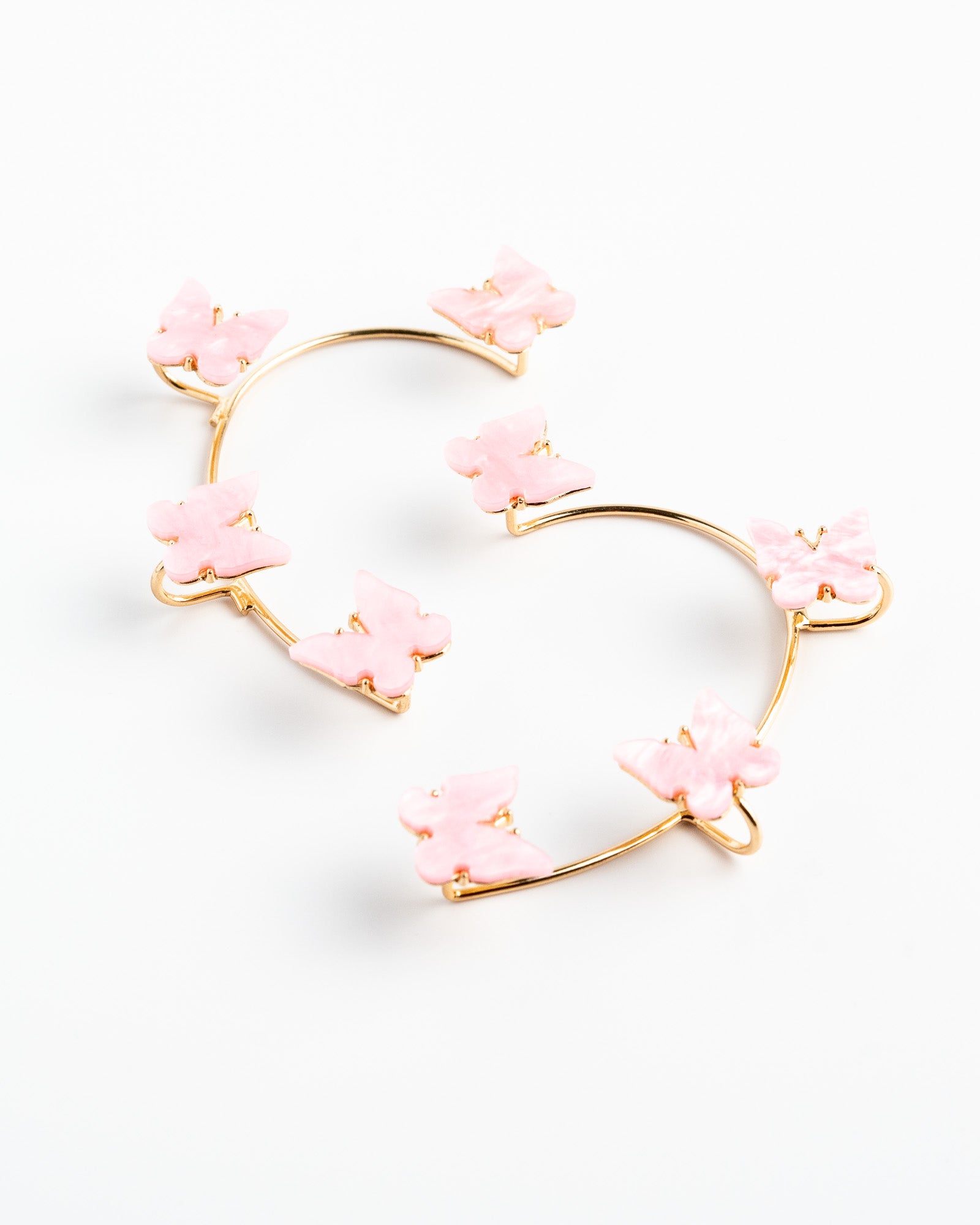 Heart-shaped earrings with pink floral elements on a white background