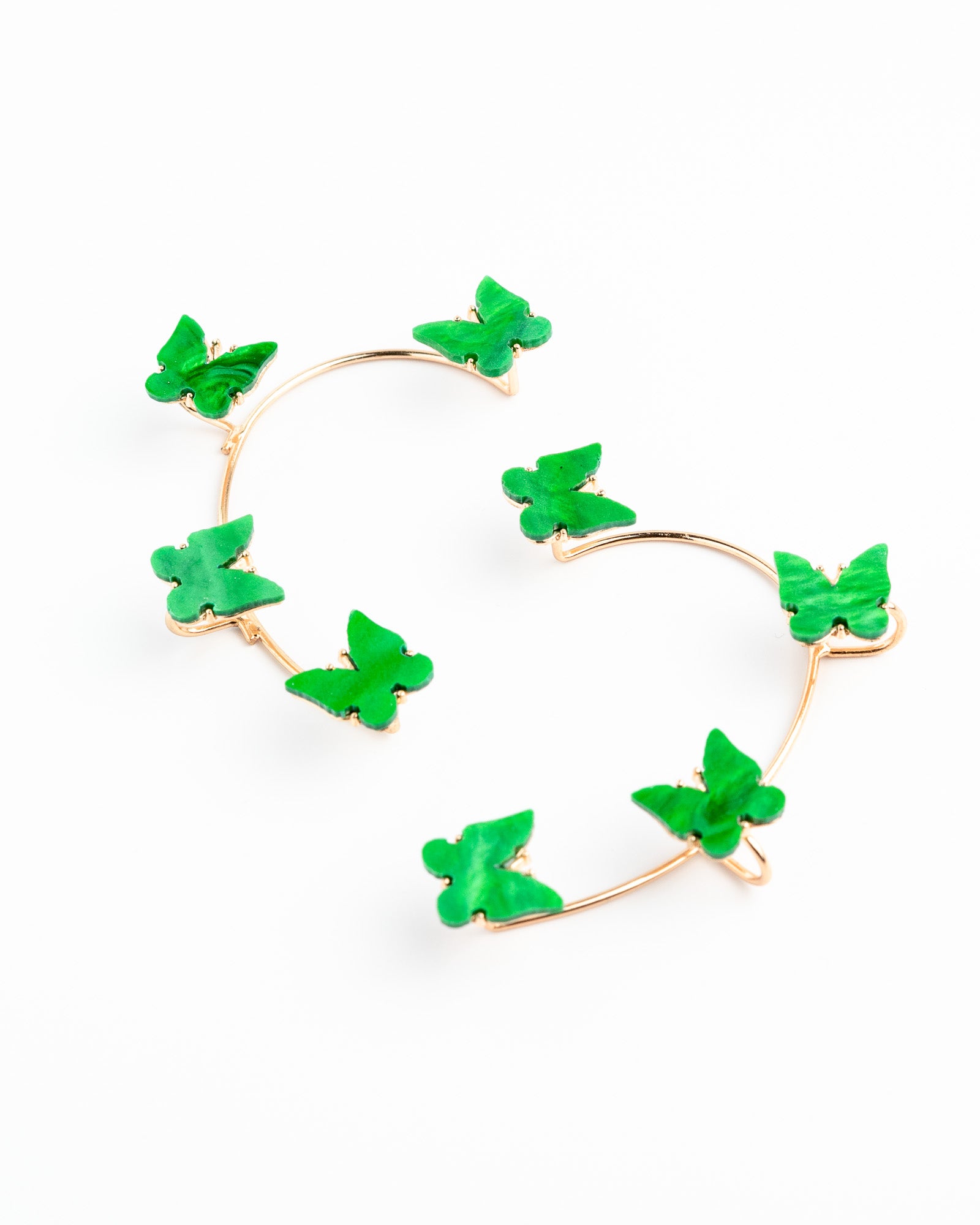 Heart-shaped earrings with green floral elements on a white background