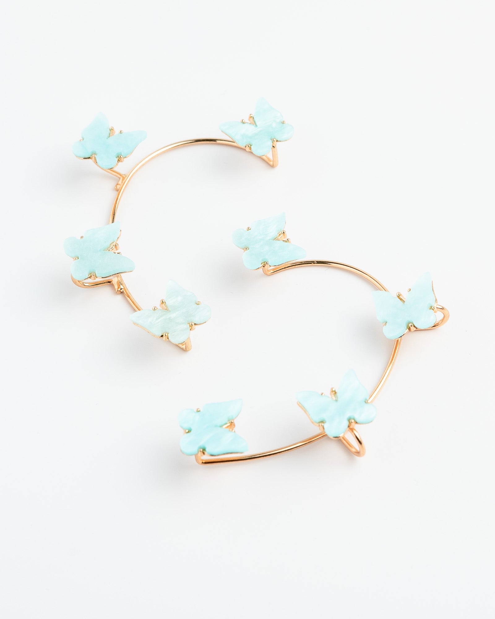 Heart-shaped earrings with sky blue floral elements on a white background