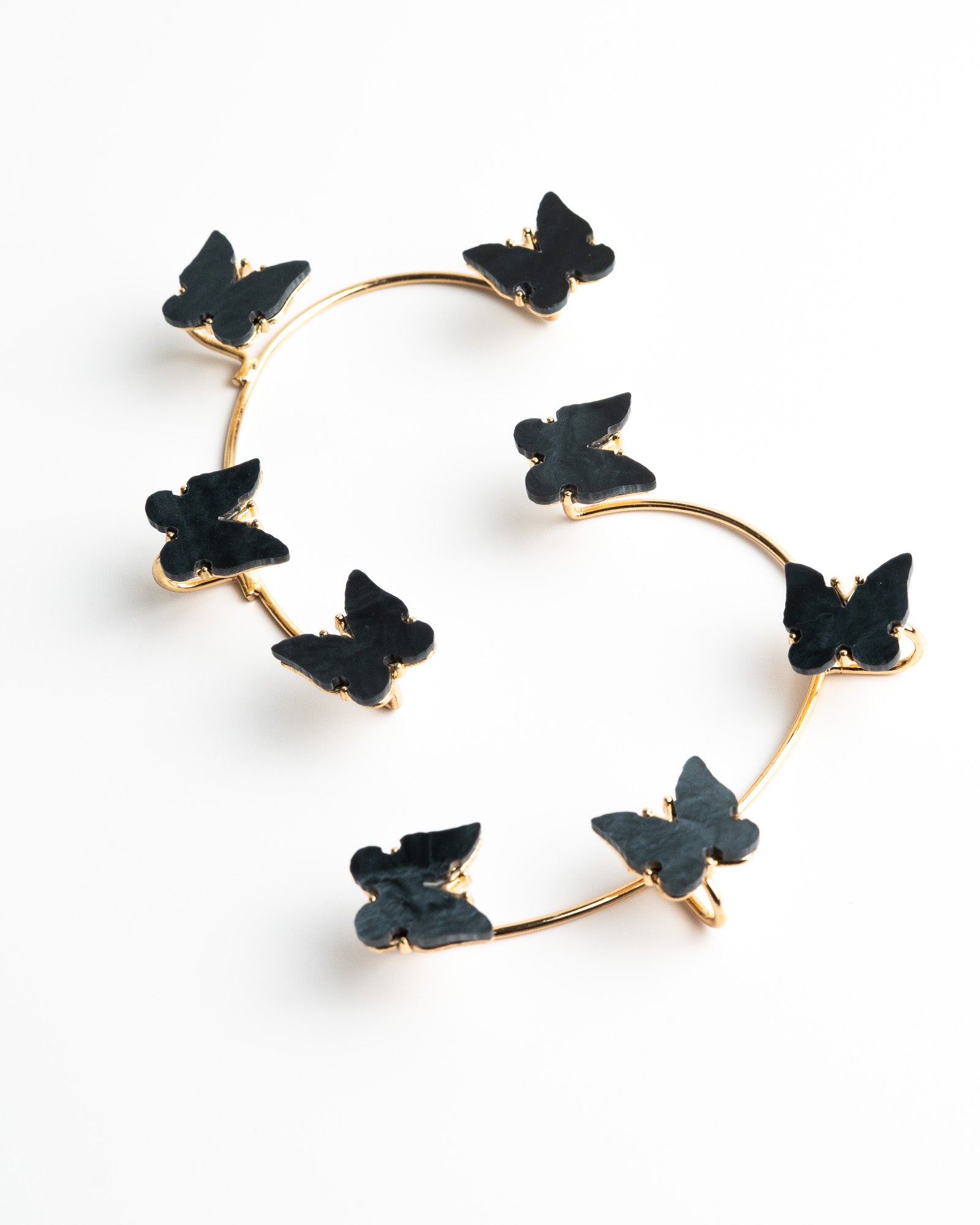 Heart-shaped earrings with black floral elements on a white background