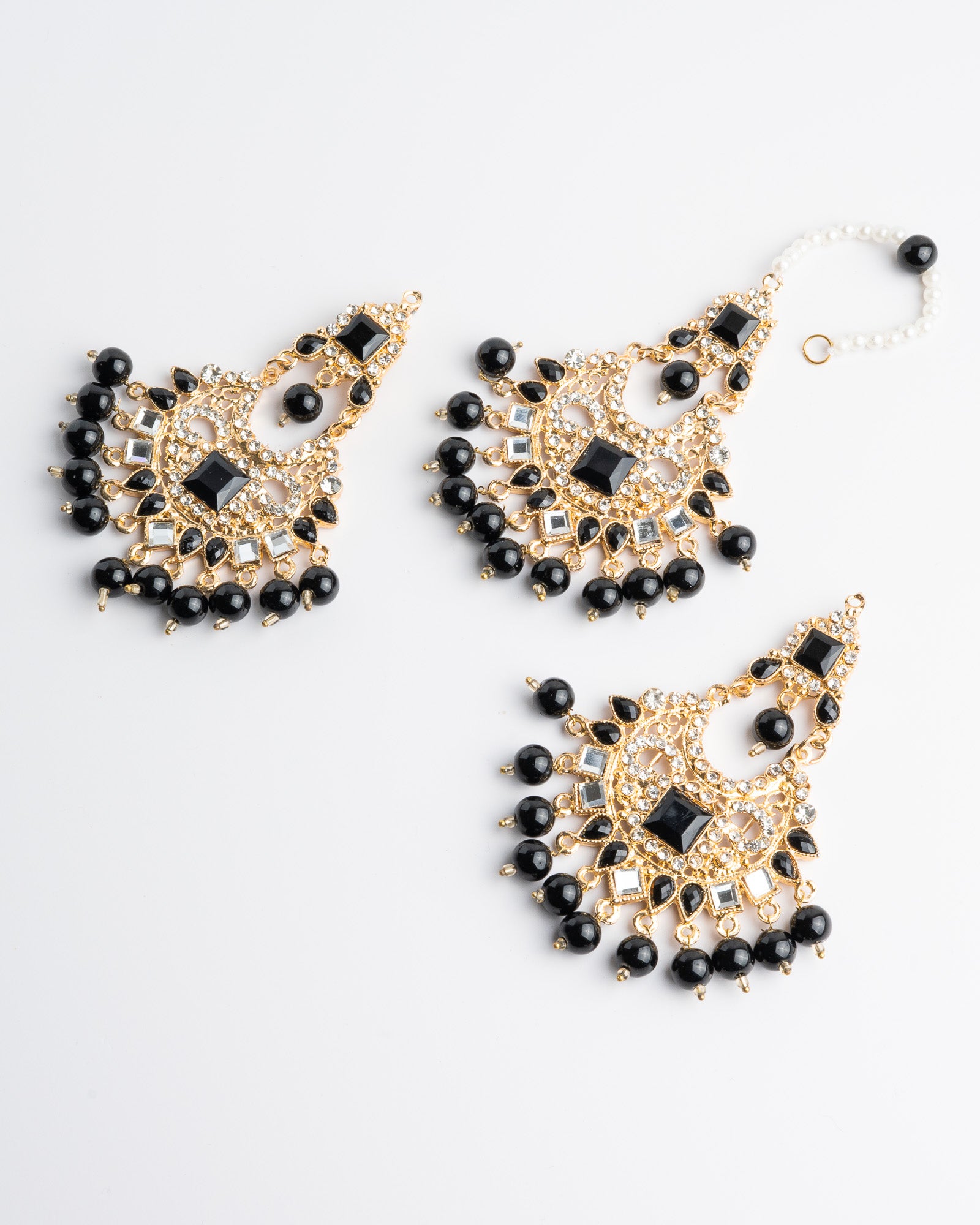 Black beaded earrings set with gold accents on a white background