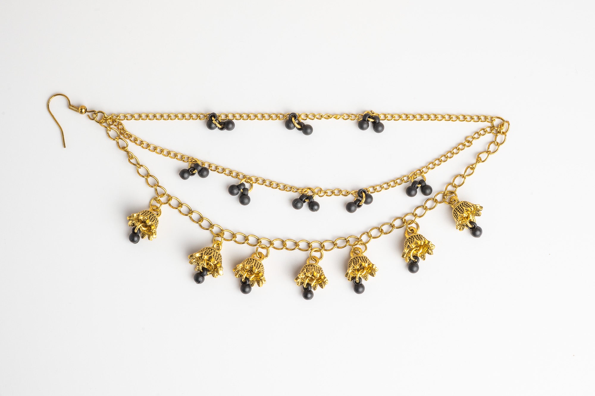 Pair of golden ear chains with black beads on a white background