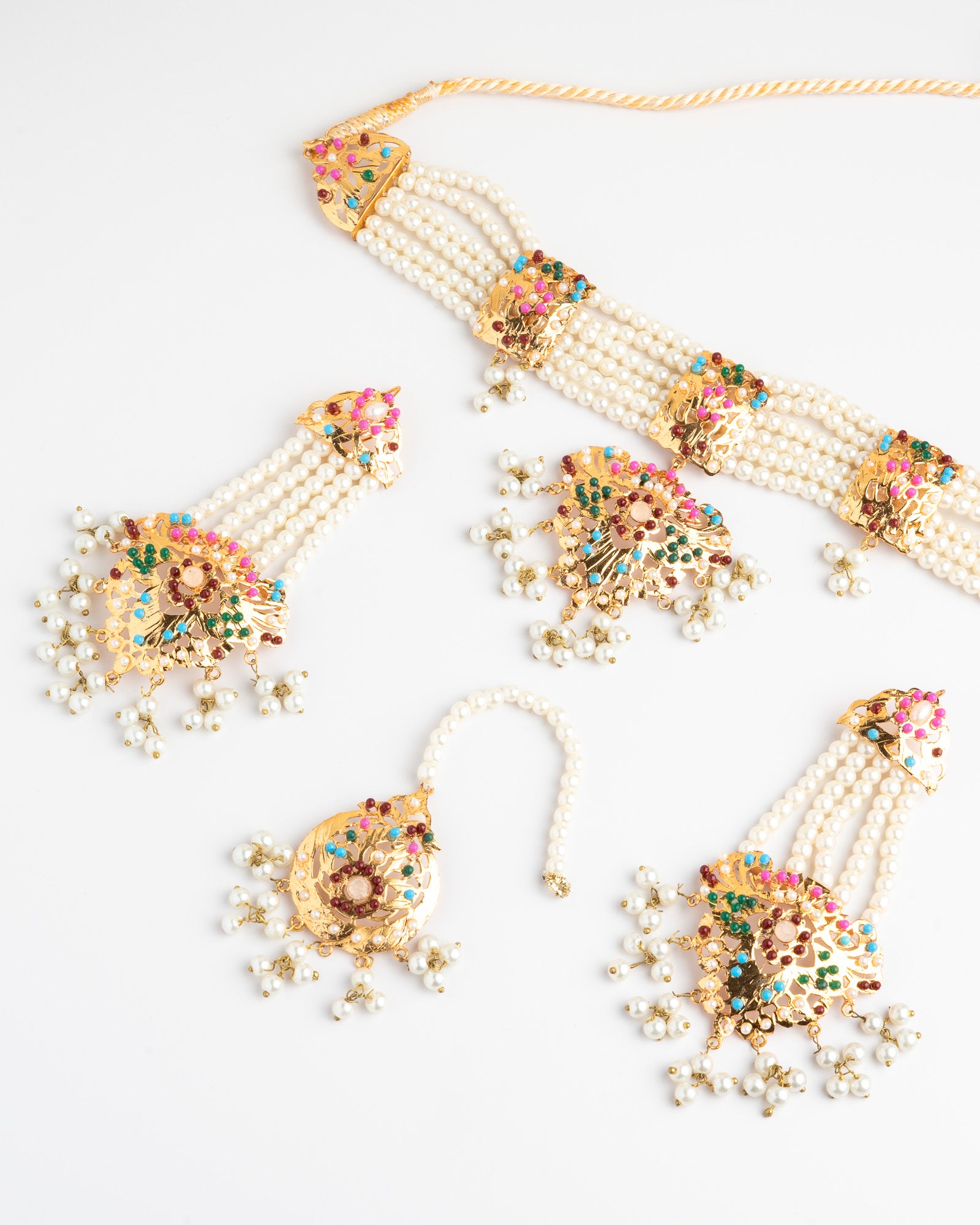 Set of pearl jewelry with colorful embellishments on a white background