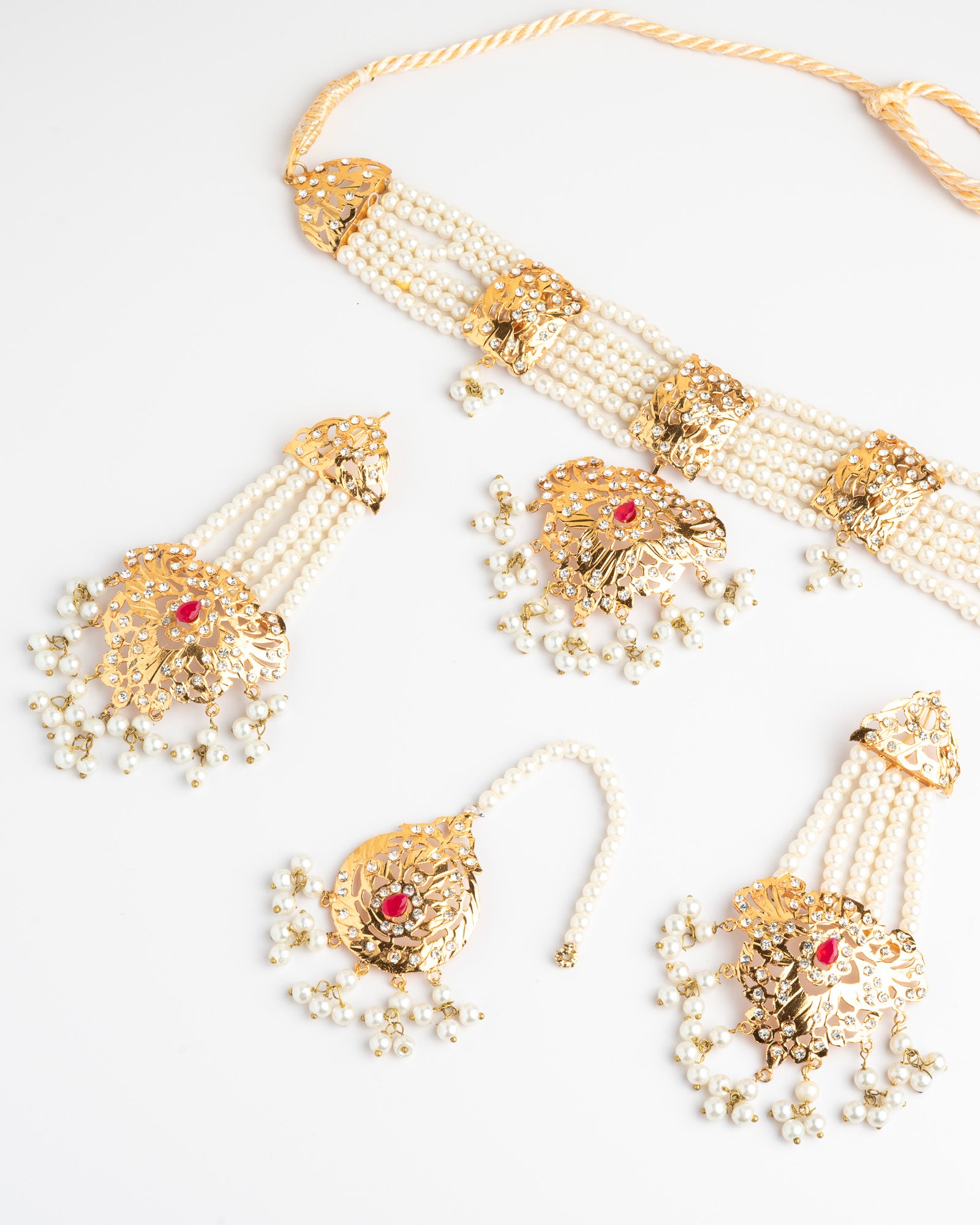 Golden and pearl jewelry set on a white background