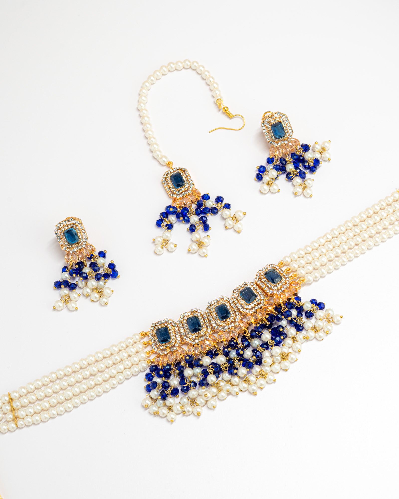 stones and beaded jewelry set with necklace, earrings, and maang tikka on a white background